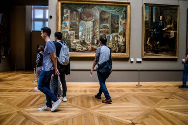 Paris, Fransa - 08 Eylül 2022 Dünyanın en büyük müzesi Louvre, sanat için ikonik bir yer, ziyaretçiler mermer heykellere ve usta resimlere hayran olmak için koridorlarda dolaşıyorlar.