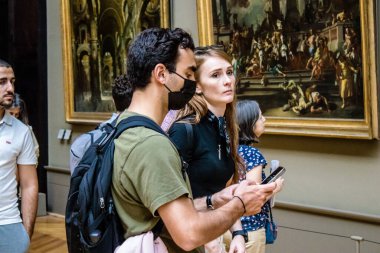 Paris, Fransa - 08 Eylül 2022 Dünyanın en büyük müzesi Louvre, sanat için ikonik bir yer, ziyaretçiler mermer heykellere ve usta resimlere hayran olmak için koridorlarda dolaşıyorlar.