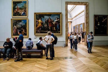 Paris, Fransa - 08 Eylül 2022 Dünyanın en büyük müzesi Louvre, sanat için ikonik bir yer, ziyaretçiler mermer heykellere ve usta resimlere hayran olmak için koridorlarda dolaşıyorlar.