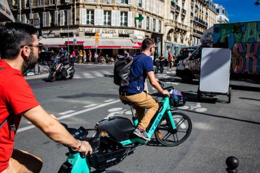 Paris, Fransa - 12 Eylül 2022 Sokaklarda bisiklet kullanan insanlar, Parisliler ve turistler tarafından yaygın olarak kullanılıyor, başkentte bu ulaşım modelini desteklemek için birçok bisiklet yolu mevcuttur