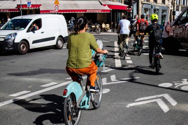 Paris, Fransa - 12 Eylül 2022 Sokaklarda bisiklet kullanan insanlar, Parisliler ve turistler tarafından yaygın olarak kullanılıyor, başkentte bu ulaşım modelini desteklemek için birçok bisiklet yolu mevcuttur