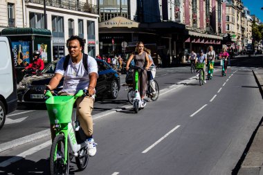 Paris, Fransa - 12 Eylül 2022 Sokaklarda bisiklet kullanan insanlar, Parisliler ve turistler tarafından yaygın olarak kullanılıyor, başkentte bu ulaşım modelini desteklemek için birçok bisiklet yolu mevcuttur