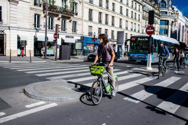 Paris, Fransa - 12 Eylül 2022 Sokaklarda bisiklet kullanan insanlar, Parisliler ve turistler tarafından yaygın olarak kullanılıyor, başkentte bu ulaşım modelini desteklemek için birçok bisiklet yolu mevcuttur