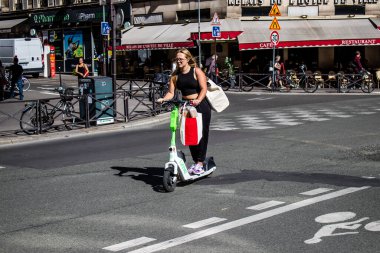 Paris, Fransa - 14 Eylül 2022 Paris sokaklarında elektrikli scooterla dolaşan insanlar, küçük bir iç yanmalı motorlar ve merkezde bir güverte ile çalışıyorlar.