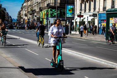 Paris, Fransa - 14 Eylül 2022 Paris sokaklarında elektrikli scooterla dolaşan insanlar, küçük bir iç yanmalı motorlar ve merkezde bir güverte ile çalışıyorlar.