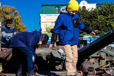 Ukrayna, Kyiv 'deki Mykhailivska Meydanı' ndaki imha edilmiş Rus askeri teçhizatı sergisinde, 16 Ekim 2022 Ukraynalı çocuklar imha edilmiş Rus askeri teçhizatıyla eğleniyorlar, burayı oyun alanı olarak kullanıyorlar..