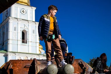 Ukrayna, Kyiv 'deki Mykhailivska Meydanı' ndaki imha edilmiş Rus askeri teçhizatı sergisinde, 16 Ekim 2022 Ukraynalı çocuklar imha edilmiş Rus askeri teçhizatıyla eğleniyorlar, burayı oyun alanı olarak kullanıyorlar..