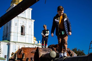 Ukrayna, Kyiv 'deki Mykhailivska Meydanı' ndaki imha edilmiş Rus askeri teçhizatı sergisinde, 16 Ekim 2022 Ukraynalı çocuklar imha edilmiş Rus askeri teçhizatıyla eğleniyorlar, burayı oyun alanı olarak kullanıyorlar..