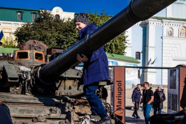 Ukrayna, Kyiv 'deki Mykhailivska Meydanı' ndaki imha edilmiş Rus askeri teçhizatı sergisinde, 16 Ekim 2022 Ukraynalı çocuklar imha edilmiş Rus askeri teçhizatıyla eğleniyorlar, burayı oyun alanı olarak kullanıyorlar..