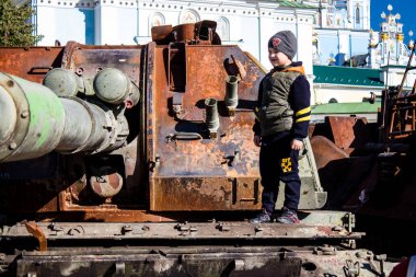 Ukrayna, Kyiv 'deki Mykhailivska Meydanı' ndaki imha edilmiş Rus askeri teçhizatı sergisinde, 16 Ekim 2022 Ukraynalı çocuklar imha edilmiş Rus askeri teçhizatıyla eğleniyorlar, burayı oyun alanı olarak kullanıyorlar..