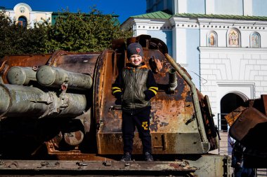 Ukrayna, Kyiv 'deki Mykhailivska Meydanı' ndaki imha edilmiş Rus askeri teçhizatı sergisinde, 16 Ekim 2022 Ukraynalı çocuklar imha edilmiş Rus askeri teçhizatıyla eğleniyorlar, burayı oyun alanı olarak kullanıyorlar..