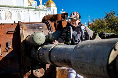 Ukrayna, Kyiv 'deki Mykhailivska Meydanı' ndaki imha edilmiş Rus askeri teçhizatı sergisinde, 16 Ekim 2022 Ukraynalı çocuklar imha edilmiş Rus askeri teçhizatıyla eğleniyorlar, burayı oyun alanı olarak kullanıyorlar..