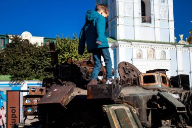 Ukrayna, Kyiv 'deki Mykhailivska Meydanı' ndaki imha edilmiş Rus askeri teçhizatı sergisinde, 16 Ekim 2022 Ukraynalı çocuklar imha edilmiş Rus askeri teçhizatıyla eğleniyorlar, bunu bir oyun grubu olarak kullanıyorlar.