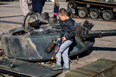 Ukrayna, Kyiv 'deki Mykhailivska Meydanı' ndaki imha edilmiş Rus askeri teçhizatı sergisinde, 16 Ekim 2022 Ukraynalı çocuklar imha edilmiş Rus askeri teçhizatıyla eğleniyorlar, bunu bir oyun grubu olarak kullanıyorlar.