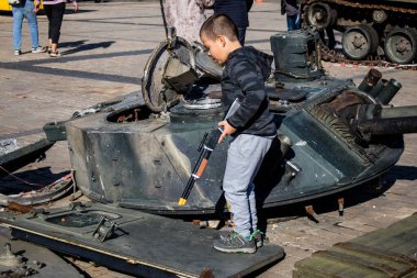 Ukrayna, Kyiv 'deki Mykhailivska Meydanı' ndaki imha edilmiş Rus askeri teçhizatı sergisinde, 16 Ekim 2022 Ukraynalı çocuklar imha edilmiş Rus askeri teçhizatıyla eğleniyorlar, bunu bir oyun grubu olarak kullanıyorlar.