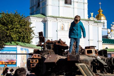 Ukrayna, Kyiv 'deki Mykhailivska Meydanı' ndaki imha edilmiş Rus askeri teçhizatı sergisinde, 16 Ekim 2022 Ukraynalı çocuklar imha edilmiş Rus askeri teçhizatıyla eğleniyorlar, bunu bir oyun grubu olarak kullanıyorlar.