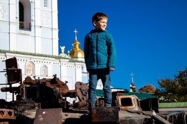 Ukrayna, Kyiv 'deki Mykhailivska Meydanı' ndaki imha edilmiş Rus askeri teçhizatı sergisinde, 16 Ekim 2022 Ukraynalı çocuklar imha edilmiş Rus askeri teçhizatıyla eğleniyorlar, bunu bir oyun grubu olarak kullanıyorlar.
