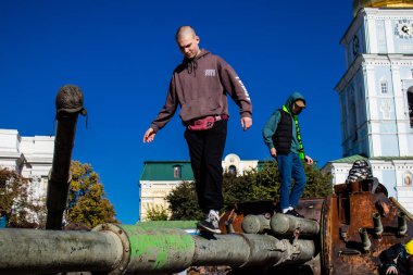 Ukrayna, Kyiv 'deki Mykhailivska Meydanı' ndaki imha edilmiş Rus askeri teçhizatı sergisinde, 16 Ekim 2022 Ukraynalı çocuklar imha edilmiş Rus askeri teçhizatıyla eğleniyorlar, bunu bir oyun grubu olarak kullanıyorlar.