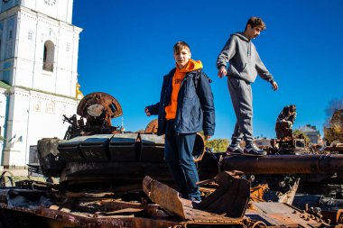 Ukrayna, Kyiv 'deki Mykhailivska Meydanı' ndaki imha edilmiş Rus askeri teçhizatı sergisinde, 16 Ekim 2022 Ukraynalı çocuklar imha edilmiş Rus askeri teçhizatıyla eğleniyorlar, bunu bir oyun grubu olarak kullanıyorlar.