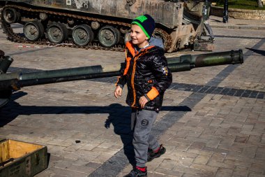 Ukrayna, Kyiv 'deki Mykhailivska Meydanı' ndaki imha edilmiş Rus askeri teçhizatı sergisinde, 16 Ekim 2022 Ukraynalı çocuklar imha edilmiş Rus askeri teçhizatıyla eğleniyorlar, bunu bir oyun grubu olarak kullanıyorlar.