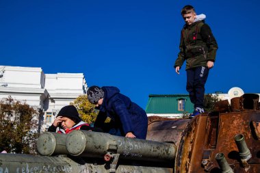 Ukrayna, Kyiv 'deki Mykhailivska Meydanı' ndaki imha edilmiş Rus askeri teçhizatı sergisinde, 16 Ekim 2022 Ukraynalı çocuklar imha edilmiş Rus askeri teçhizatıyla eğleniyorlar, bunu bir oyun grubu olarak kullanıyorlar.