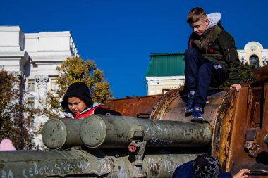 Ukrayna, Kyiv 'deki Mykhailivska Meydanı' ndaki imha edilmiş Rus askeri teçhizatı sergisinde, 16 Ekim 2022 Ukraynalı çocuklar imha edilmiş Rus askeri teçhizatıyla eğleniyorlar, bunu bir oyun grubu olarak kullanıyorlar.