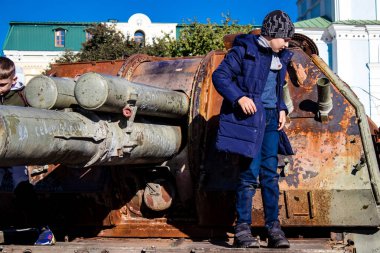 Ukrayna, Kyiv 'deki Mykhailivska Meydanı' ndaki imha edilmiş Rus askeri teçhizatı sergisinde, 16 Ekim 2022 Ukraynalı çocuklar imha edilmiş Rus askeri teçhizatıyla eğleniyorlar, bunu bir oyun grubu olarak kullanıyorlar.