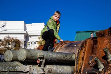Ukrayna, Kyiv 'deki Mykhailivska Meydanı' ndaki imha edilmiş Rus askeri teçhizatı sergisinde, 16 Ekim 2022 Ukraynalı çocuklar imha edilmiş Rus askeri teçhizatıyla eğleniyorlar, bunu bir oyun grubu olarak kullanıyorlar.