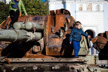 Ukrayna, Kyiv 'deki Mykhailivska Meydanı' ndaki imha edilmiş Rus askeri teçhizatı sergisinde, 16 Ekim 2022 Ukraynalı çocuklar imha edilmiş Rus askeri teçhizatıyla eğleniyorlar, bunu bir oyun grubu olarak kullanıyorlar.