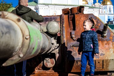 Ukrayna, Kyiv 'deki Mykhailivska Meydanı' ndaki imha edilmiş Rus askeri teçhizatı sergisinde, 16 Ekim 2022 Ukraynalı çocuklar imha edilmiş Rus askeri teçhizatıyla eğleniyorlar, bunu bir oyun grubu olarak kullanıyorlar.