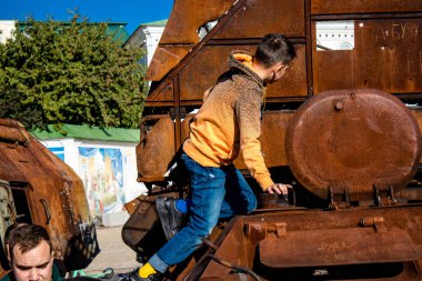 Ukrayna, Kyiv 'deki Mykhailivska Meydanı' ndaki imha edilmiş Rus askeri teçhizatı sergisinde, 16 Ekim 2022 Ukraynalı çocuklar imha edilmiş Rus askeri teçhizatıyla eğleniyorlar, burayı oyun alanı olarak kullanıyorlar.. 