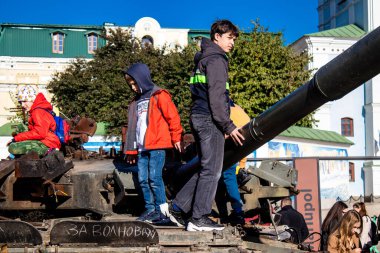 Ukrayna, Kyiv 'deki Mykhailivska Meydanı' ndaki imha edilmiş Rus askeri teçhizatı sergisinde, 16 Ekim 2022 Ukraynalı çocuklar imha edilmiş Rus askeri teçhizatıyla eğleniyorlar, burayı oyun alanı olarak kullanıyorlar.. 