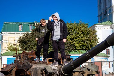 Ukrayna, Kyiv 'deki Mykhailivska Meydanı' ndaki imha edilmiş Rus askeri teçhizatı sergisinde, 16 Ekim 2022 Ukraynalı çocuklar imha edilmiş Rus askeri teçhizatıyla eğleniyorlar, burayı oyun alanı olarak kullanıyorlar.. 