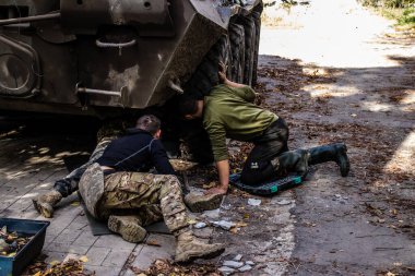 Ukrayna ordusunun hafif zırhlı aracı Barkhmunt kasabasında intihar insansız hava aracı tarafından saldırıya uğradı. Askerler çarpışmaya dönmeden önce hasarlı tekerleği doğaçlama olarak değiştiriyorlar.
