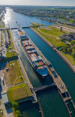Kilitteki demirli gemilerin hava görüntüsü. Kargo gemileri Kiel Kanalı 'nın Holtenau kilidini geçiyor. Holtenau yolu ile Kiel Kanalı 'nın hava görüntüsü.. 