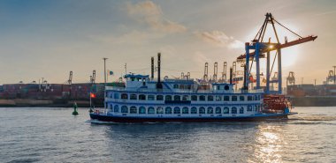 Hamburg limanında turist taşıyan vapur. Hamburg 'da güneşe karşı bir keşif gemisi. Elbe 'de geleneksel kürek buharı..