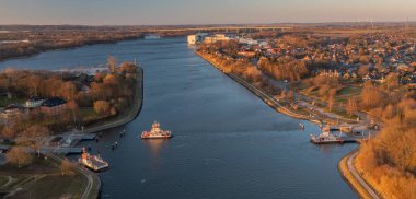 Almanya 'nın kuzeyinde Schleswig-Holstein eyâletinde, Rendsburg, Schacht-Audorf feribot terminali yakınlarındaki Kiel Kanalı ve kanal feribotunun panorama hava görüntüsü.