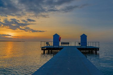Gün batımında bulutlu gökyüzüne karşı deniz manzarası. Rıhtım Stein (Baltık Denizi), Probstei, Schleswig-Holstein, Almanya.