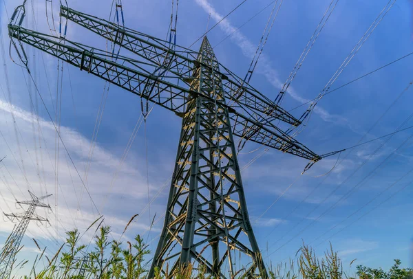 Power line, power supply with countryside landscape. Electricity grid expansion for the energy transition. Electricity pylons.