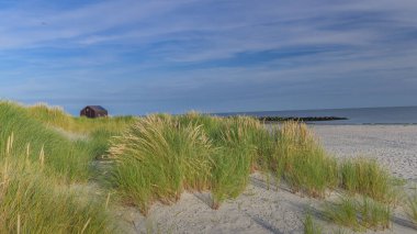 Tiny house on the seashore among sand and dunes.Cosy house in dunes at the seaside. Little house, made out of cardboard for vacation on seaside.Tiny houses on the island Dune near island Helgoland.