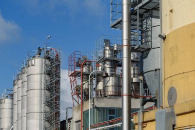 Petrol rafinerisindeki sanayi manzarası ve sanayi bölgesinden silolar. Rafineri fabrikası petrol depolama tankı. Doğal lif endüstrisinin endüstriyel fabrikasının görüntüsü. Fabrika bacası olan sanayi manzarası. 