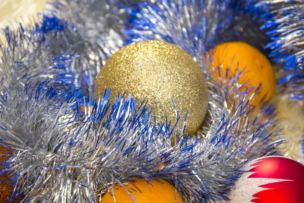 Tangerines and Christmas tree ornaments on a blue plate — Stock Photo, Image