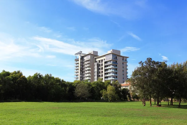 Edifício de apartamentos com grama e céu — Fotografia de Stock