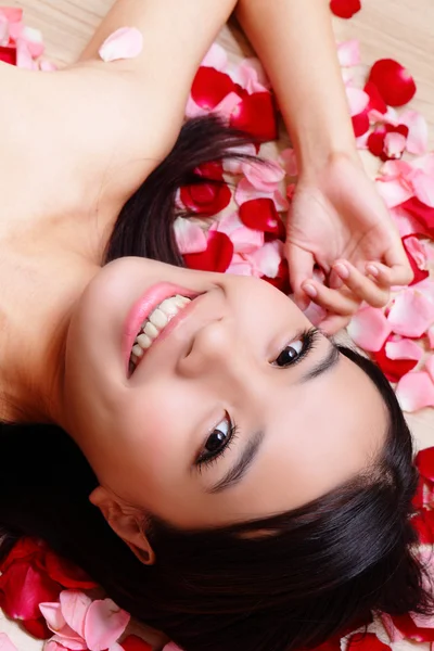 Girl smiling close-up with rose background — Stock Photo, Image