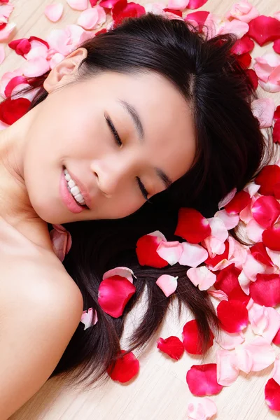 Meisje sluit haar ogen en glimlach met roos — Stockfoto