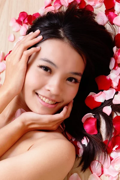 Young woman touching her face with rose — Stock Photo, Image