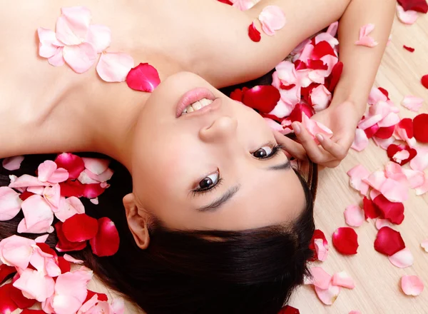 Piękna dziewczyna uśmiechając się z różą — Zdjęcie stockowe
