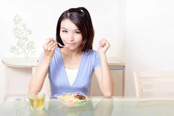 Усміхнена молода жінка їсть салат — стокове фото