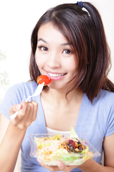 Leende ung kvinna äta sallad — Stockfoto