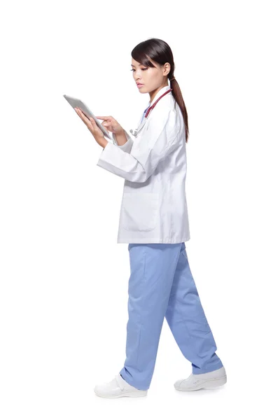 Nainen lääkäri käyttää tabletti pc ja kävely — kuvapankkivalokuva